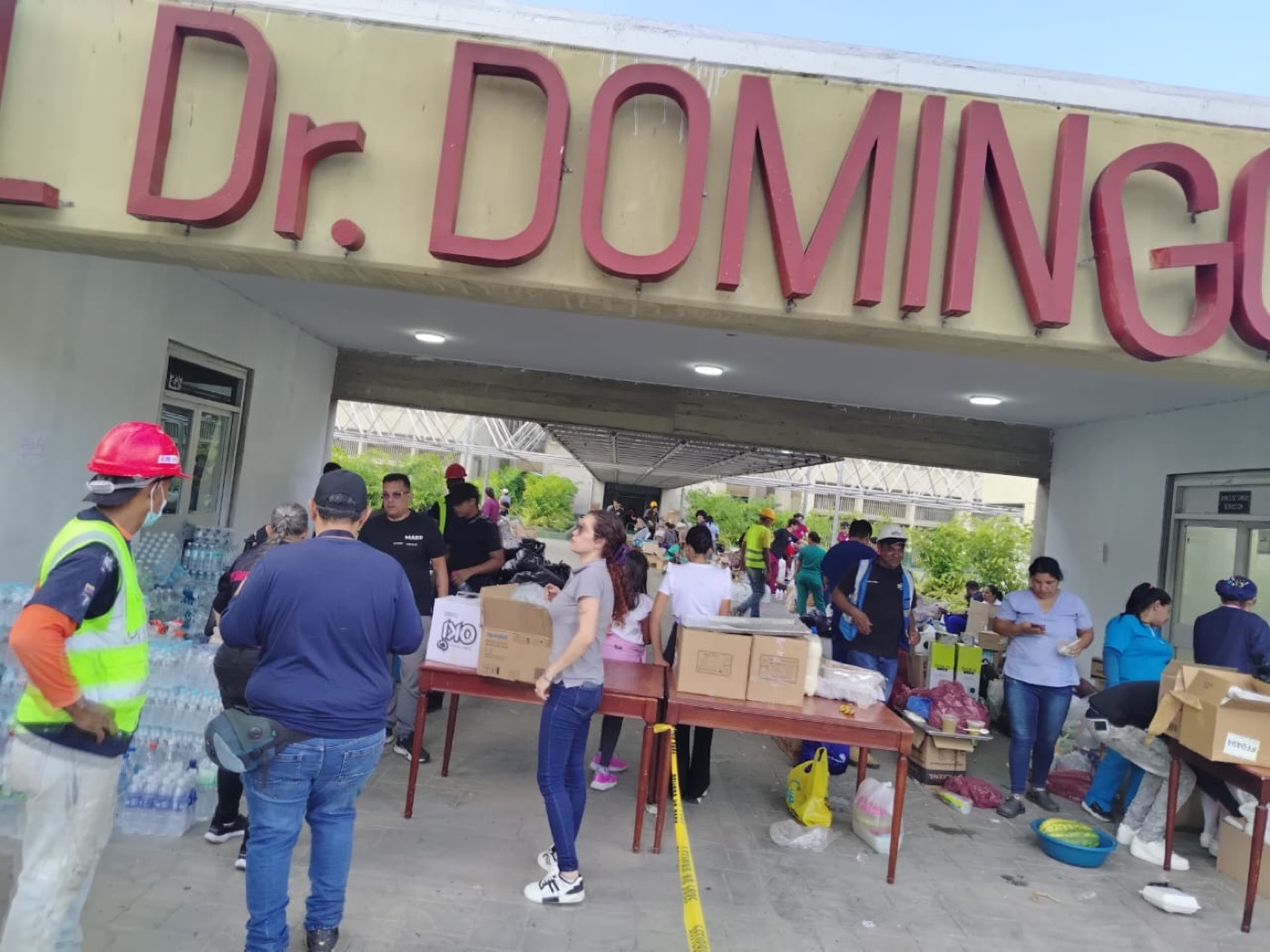 Volunteers distributing water and supplies at a hospital.